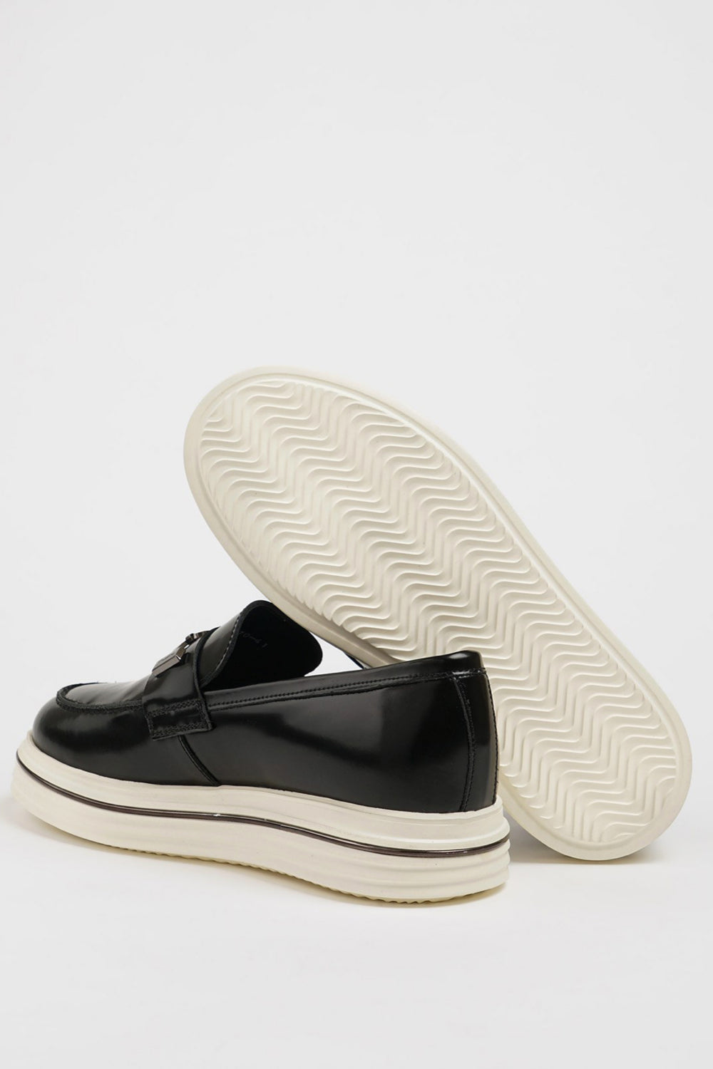 Modern black leather loafers by Mazonni with silver buckle detail and elevated white outsole