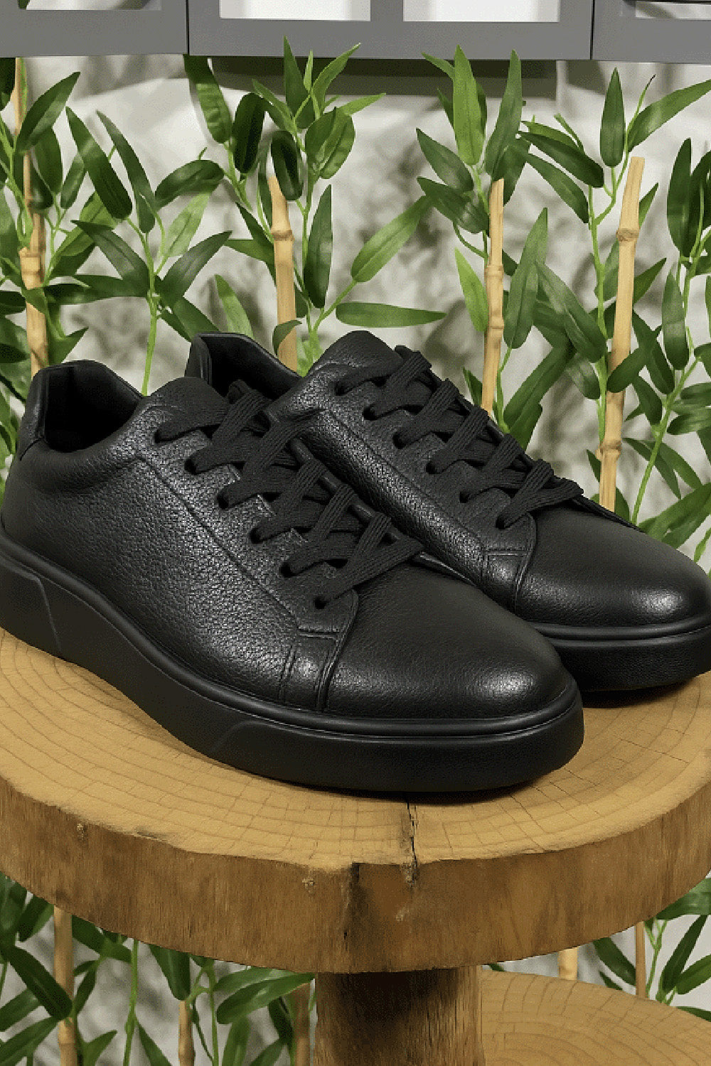 Black leather sneakers for men by Mazonni with tonal laces and minimalist design