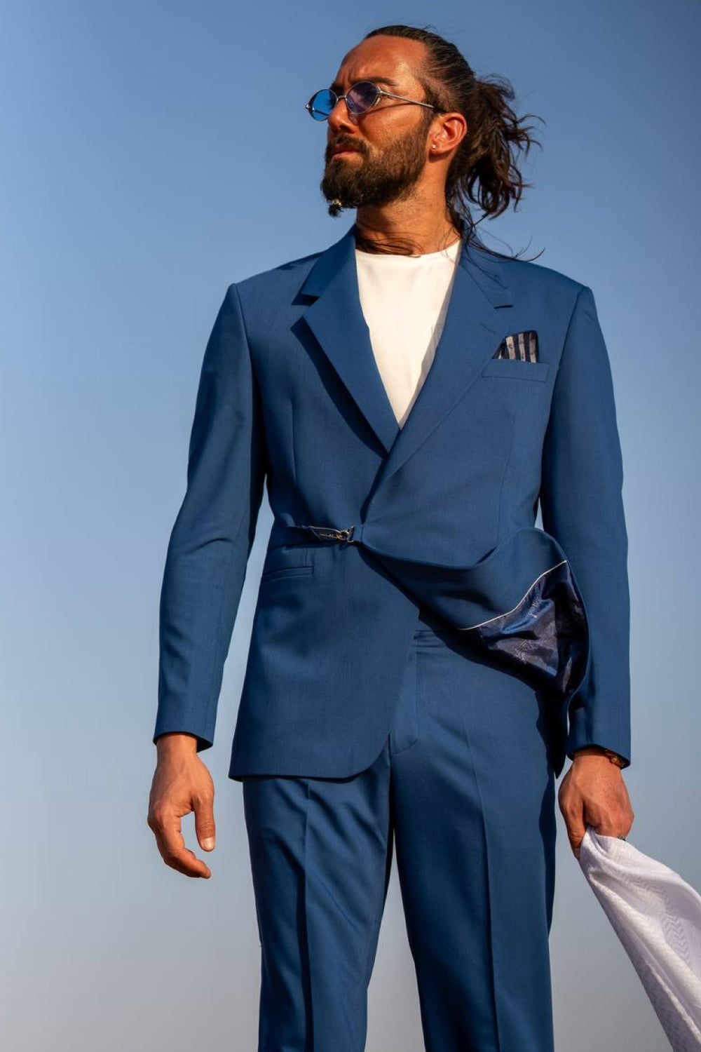 Bold cobalt blue Mazonni men's suit styled with a white top and sunglasses, perfect for fashion-forward formalwear