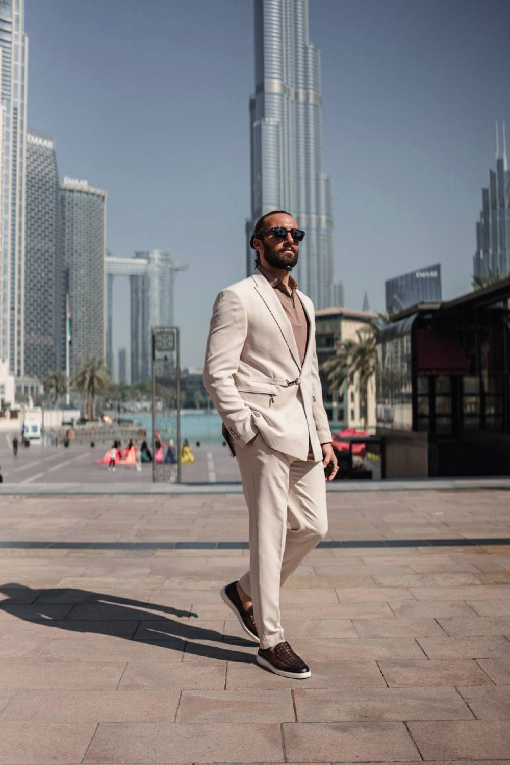 Elegant men's beige suit by Mazonni worn with dark loafers, great for urban settings and stylish professional wear