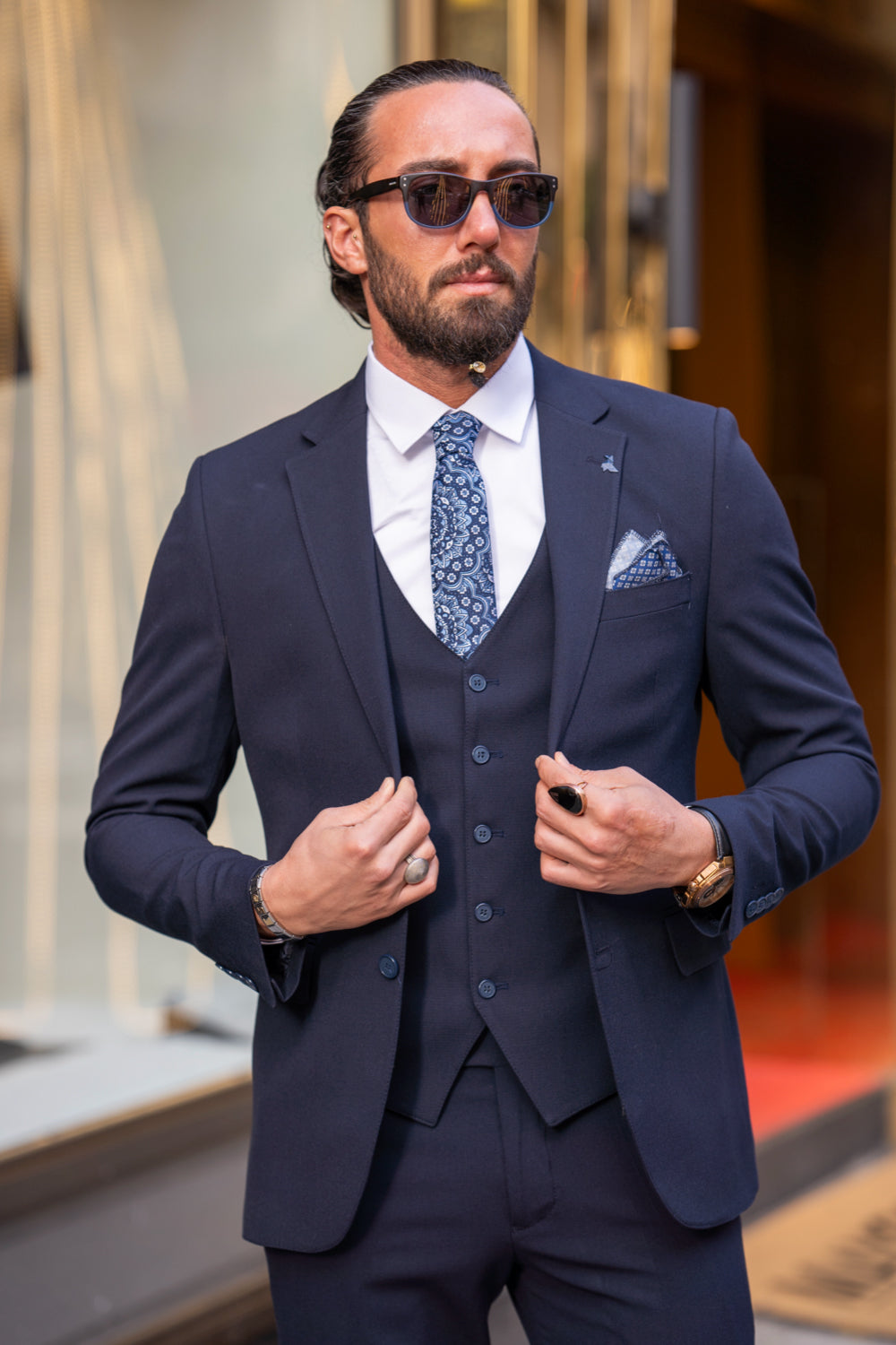 Mazonni formal navy blue suit for men featuring a classic fit, pocket square, and subtle checkered tie