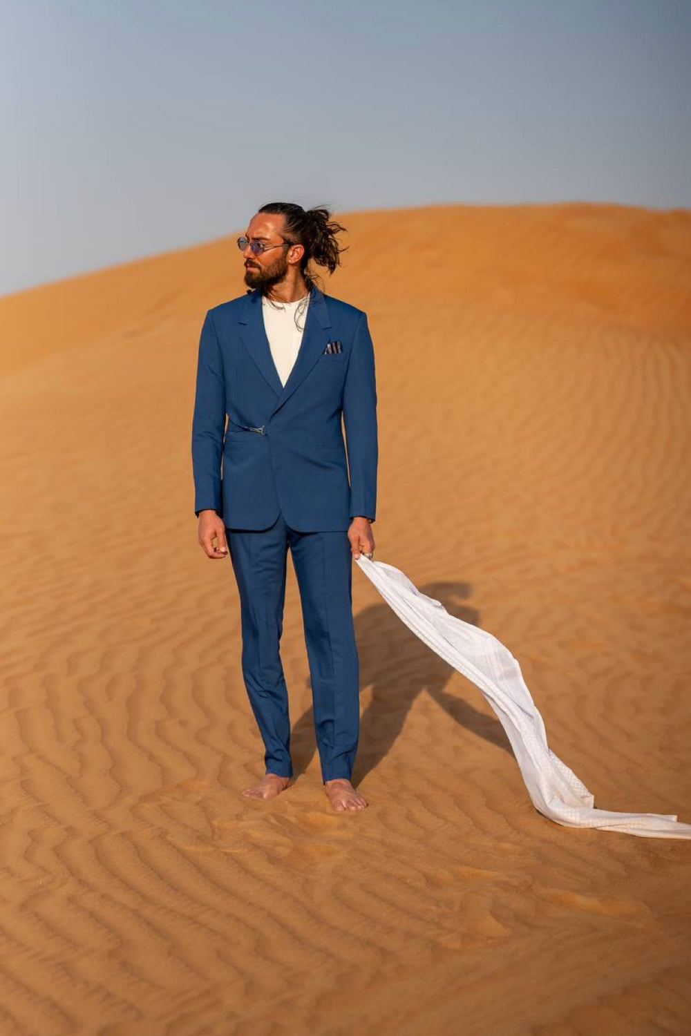Stylish men's suit in deep blue by Mazonni, paired with a clean white base layer for a high-contrast, sharp look
