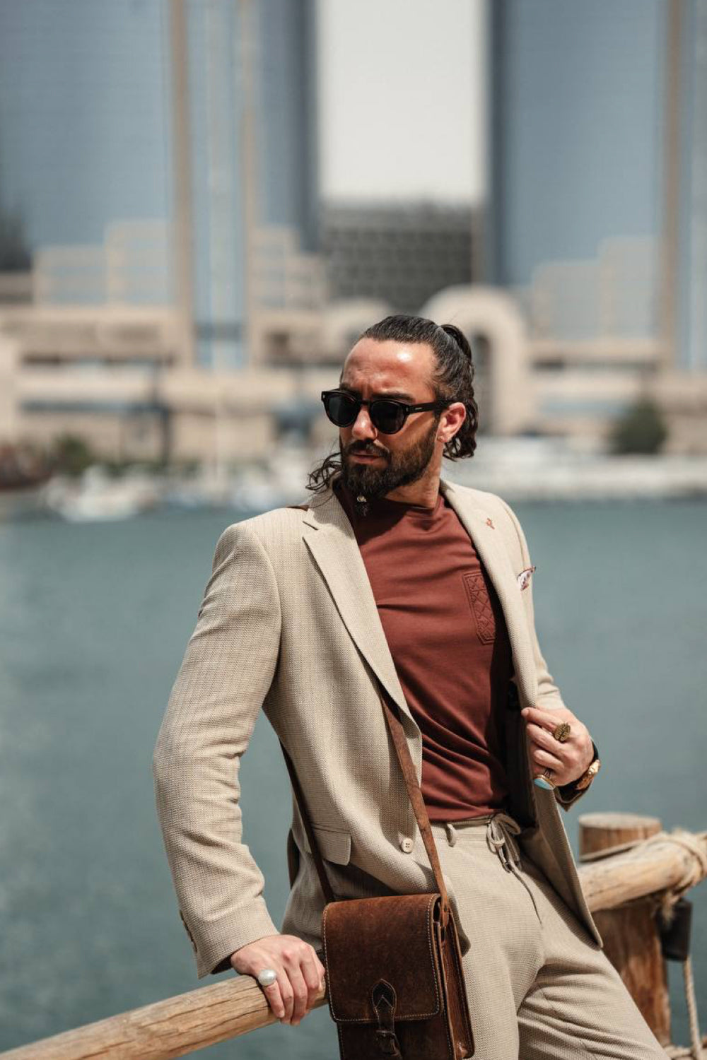Elegant beige men’s blazer and trousers set by Mazonni combined with a muted red tee, perfect outfit for modern gentleman style