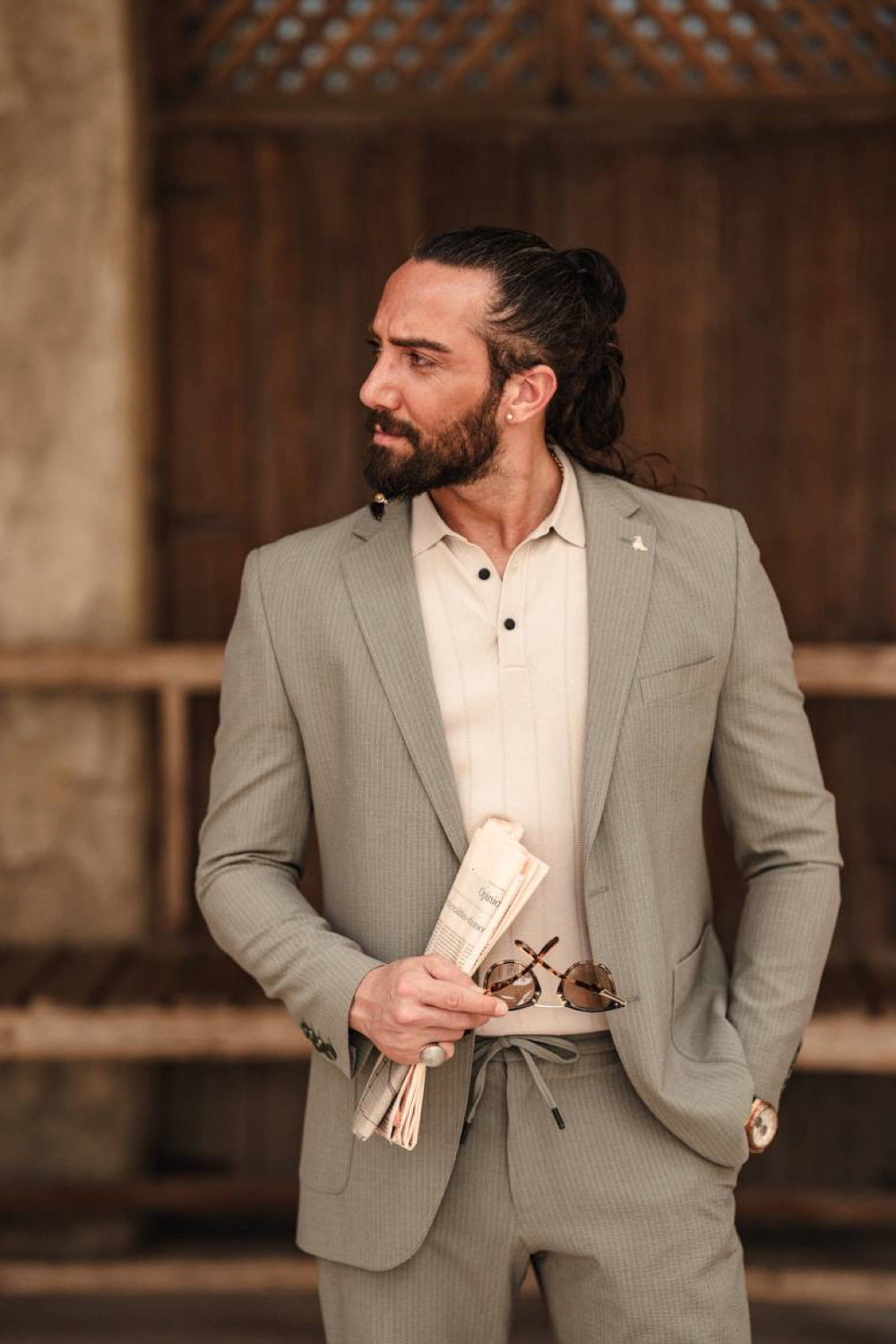 Mazonni light green suit for men with a relaxed fit, worn with a white polo and floral pocket square, ideal for summer formalwear