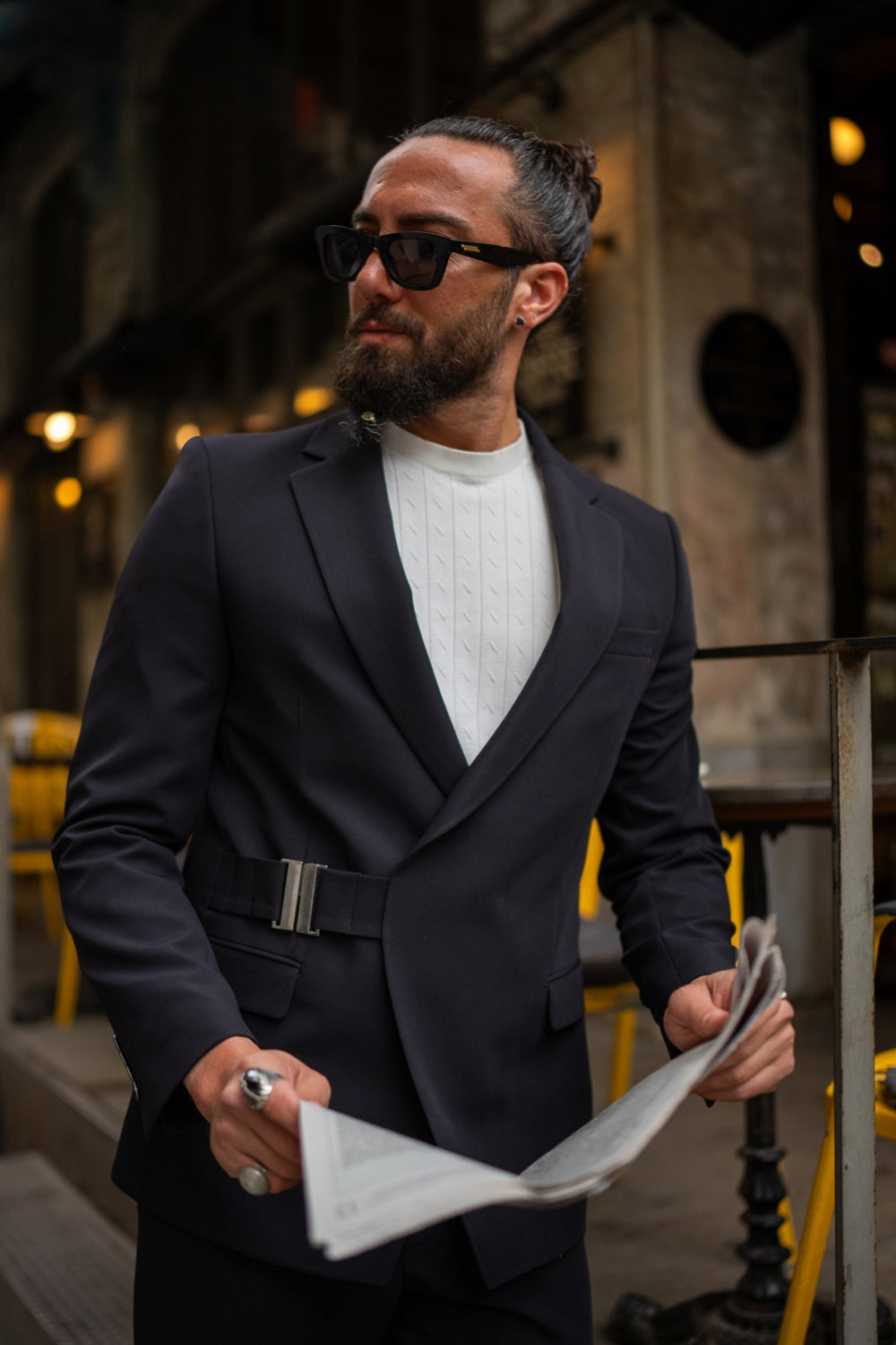 Stylish navy tailored suit by Mazonni featuring a belted jacket, worn with white sneakers for a smart-casual twist