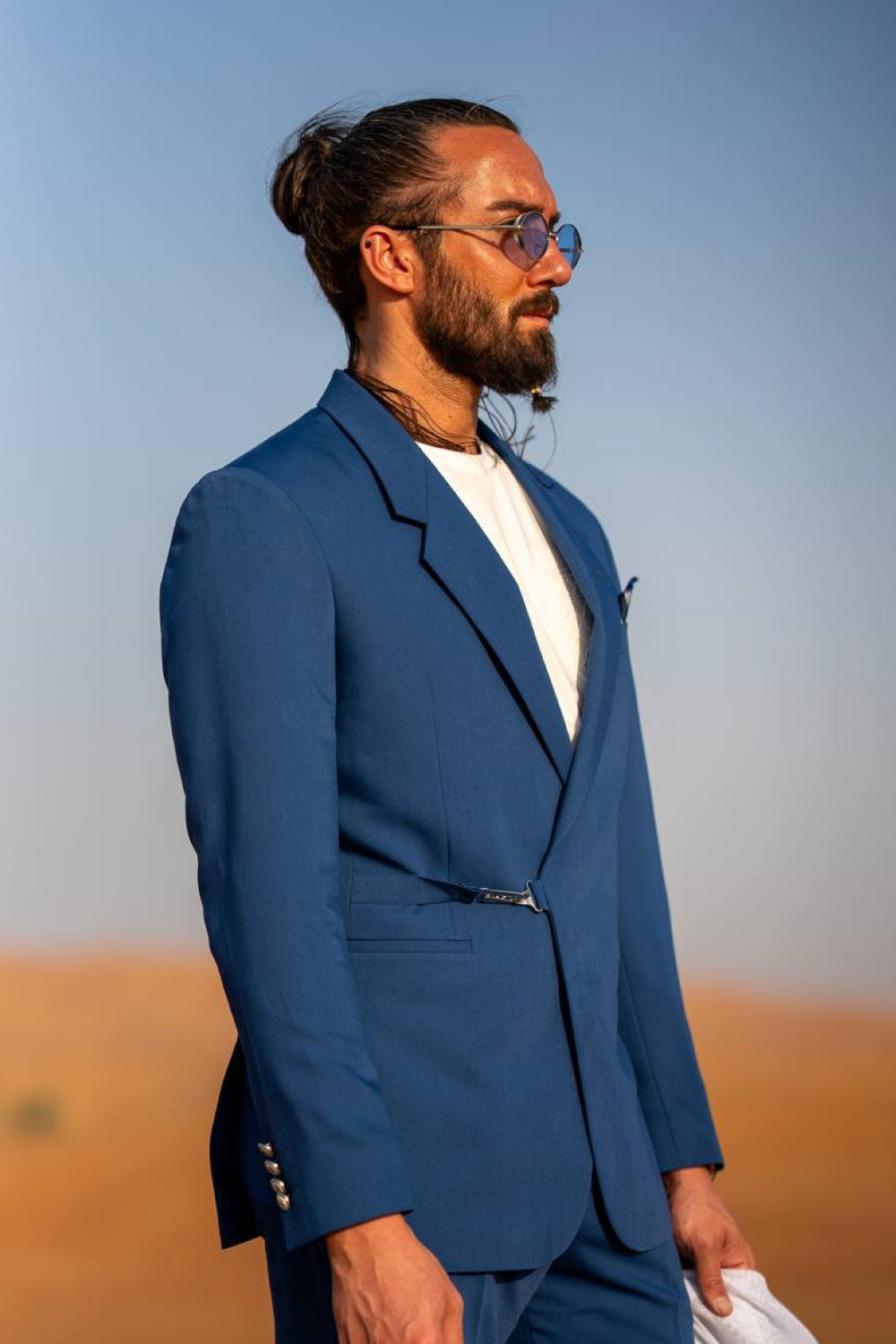 Mazonni blue suit for men showcased in a desert setting, paired with a sleek white undershirt for modern elegance