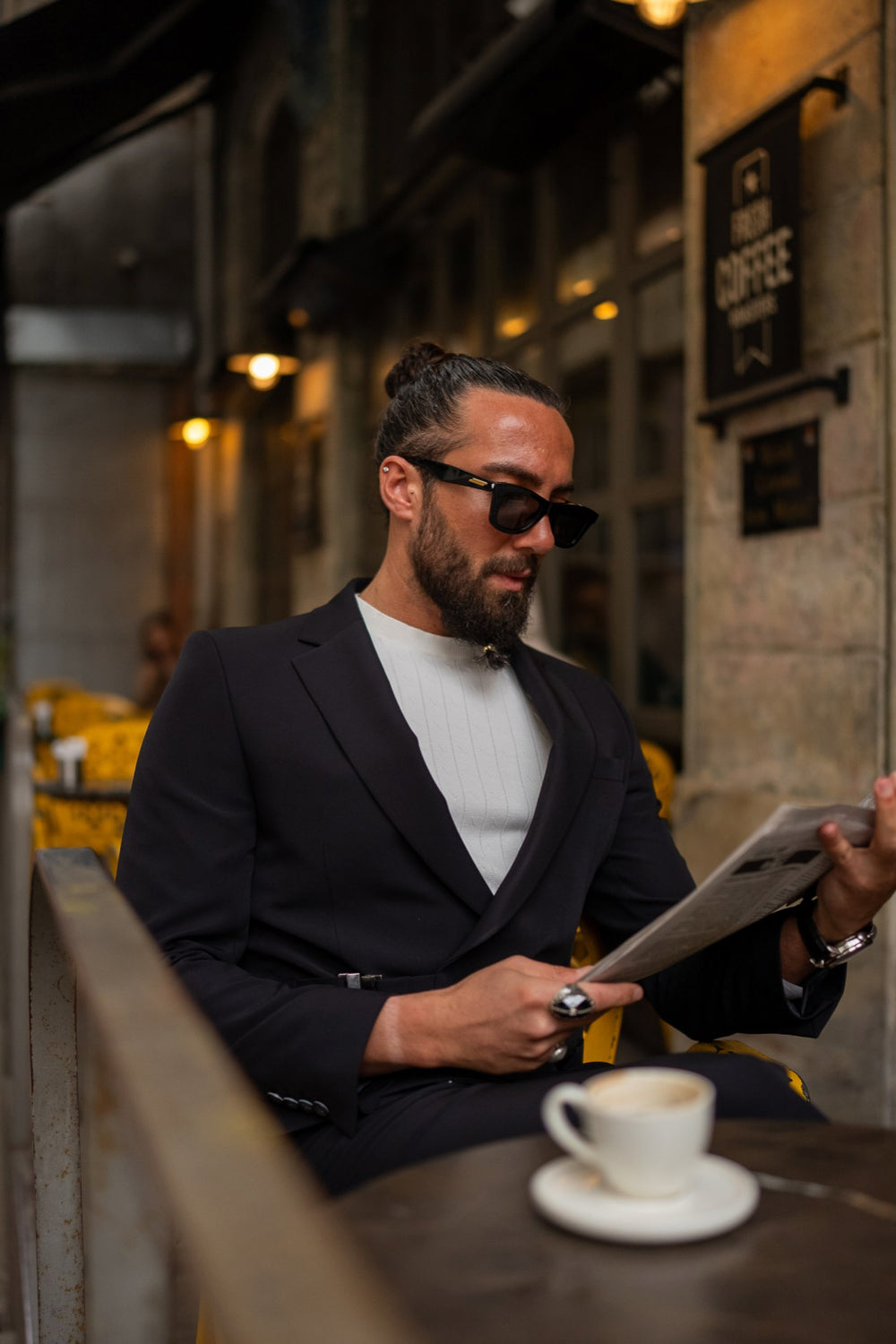 Contemporary dark blue suit from Mazonni with unique fastening detail, paired with minimalist white shirt and accessories