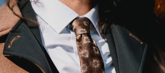 Close-up of men’s brown patterned tie with white shirt and coat – Mazonni fashion style