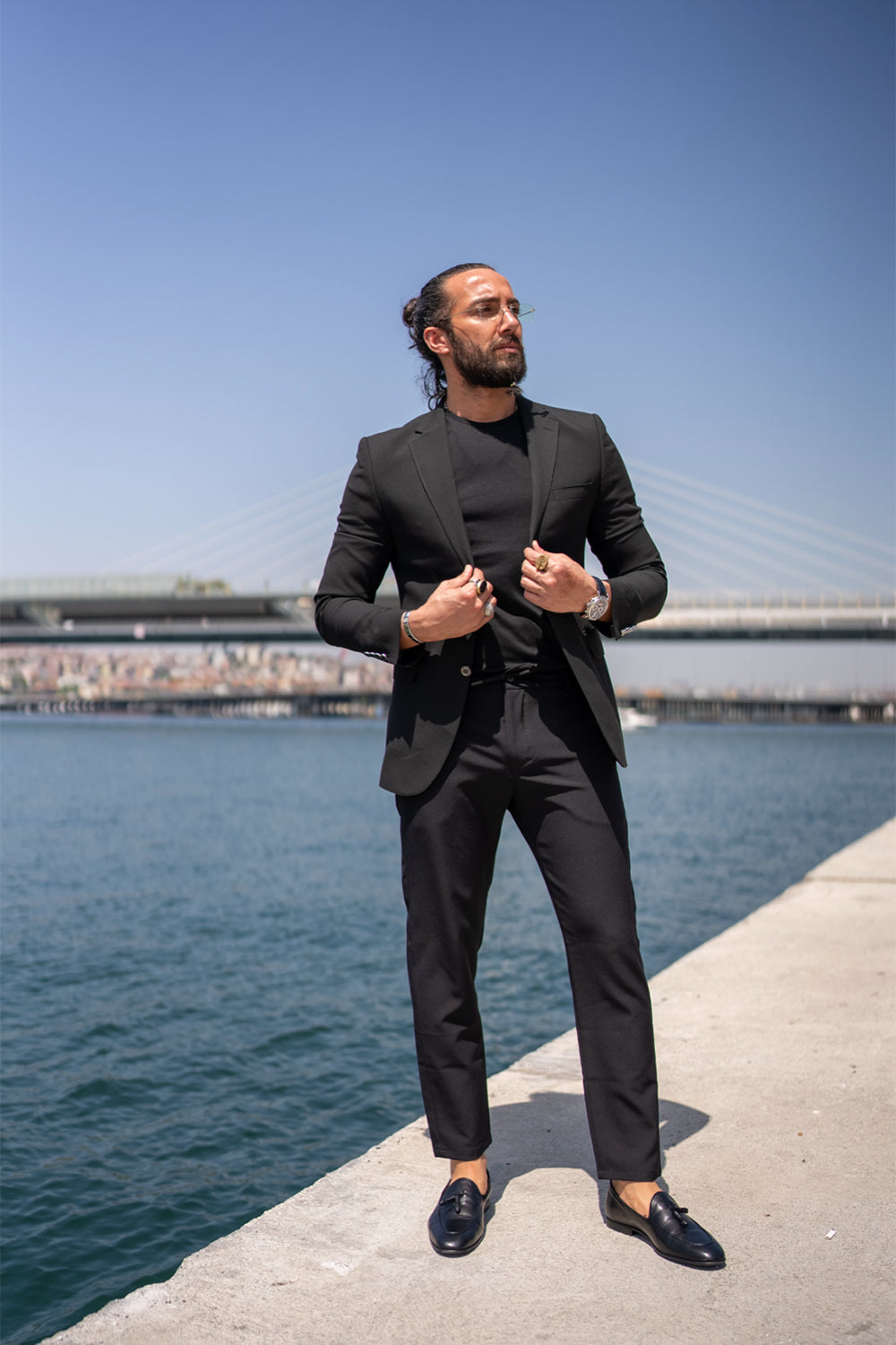 elegant men's black blazer from Mazonni, paired with black loafers and necklace for stylish streetwear vibe