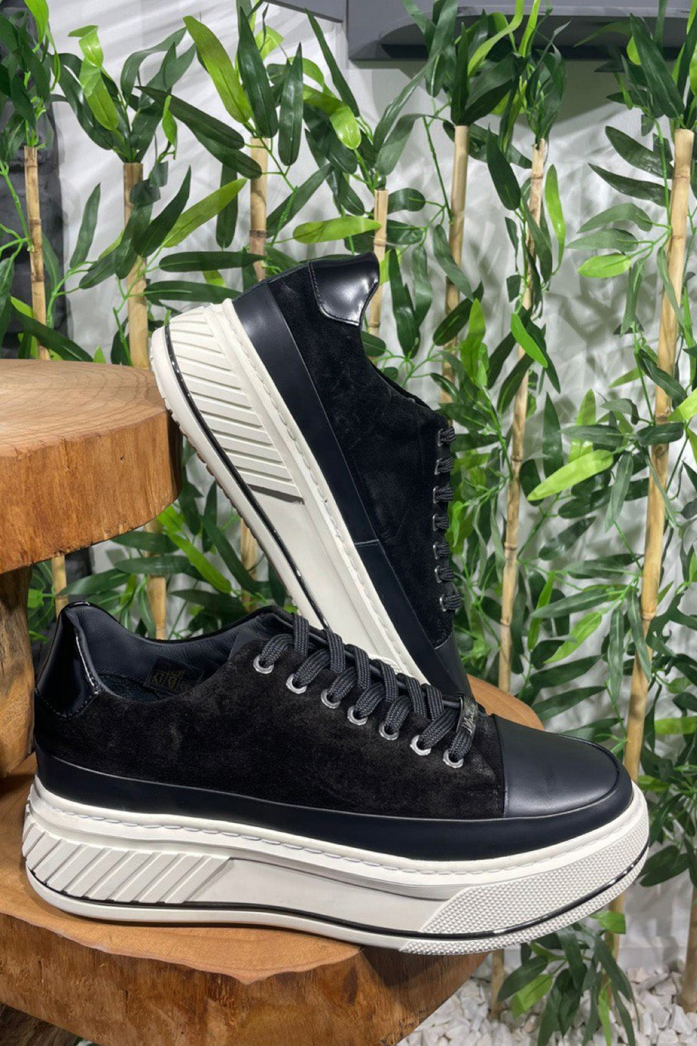 Side and sole view of black Mazonni casual shoes with elevated white platform and clean design