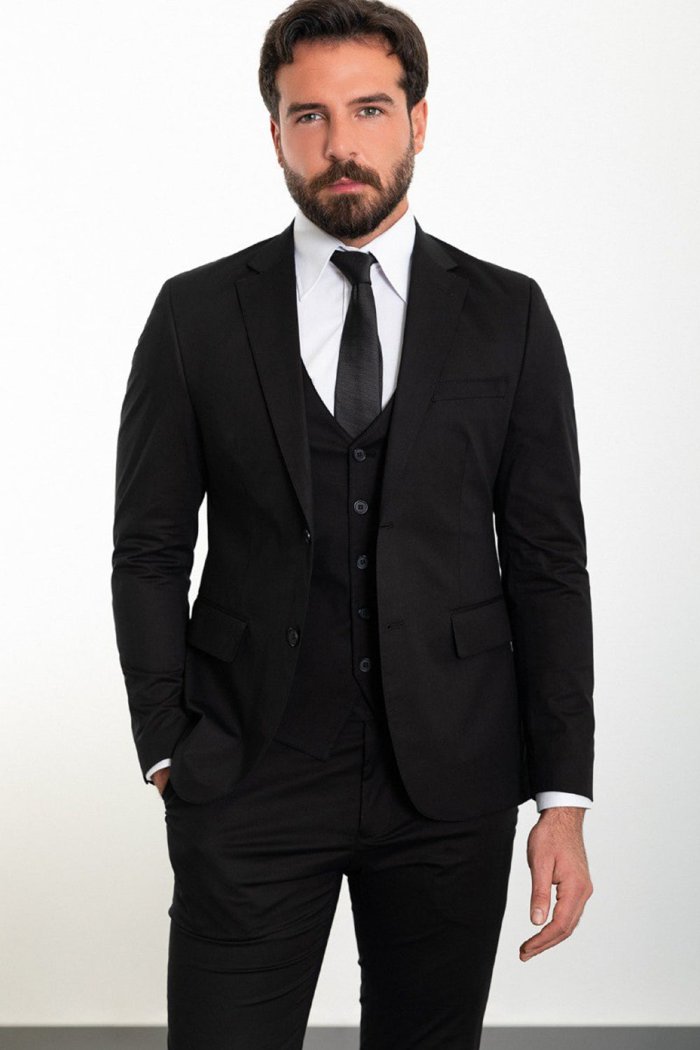 Black three-piece formal suit for men by Mazonni, including blazer, waistcoat, and trousers with classic white shirt and tie