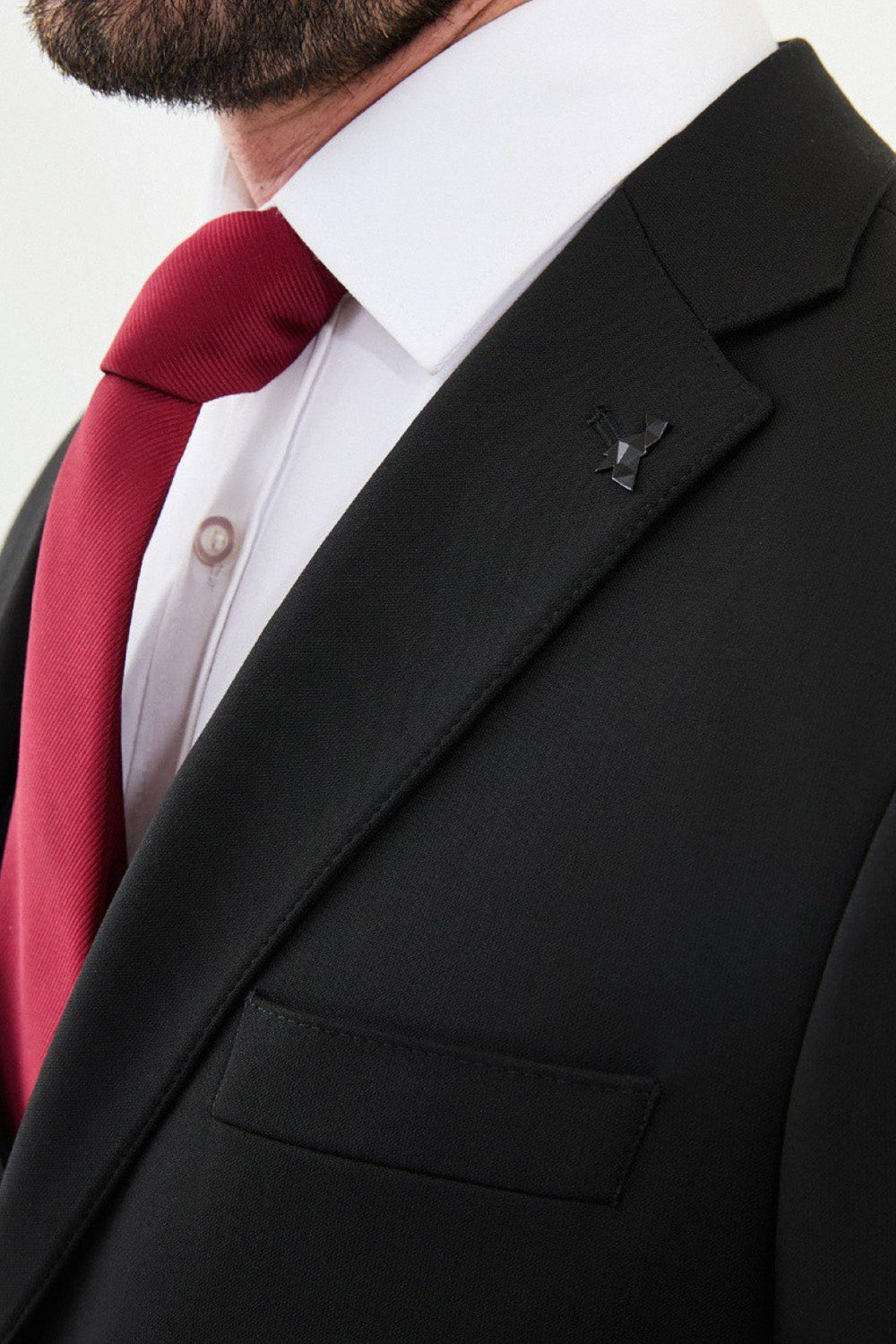 Close-up of black Mazonni suit with peak lapel and button detailing, sophisticated formal style for special events
