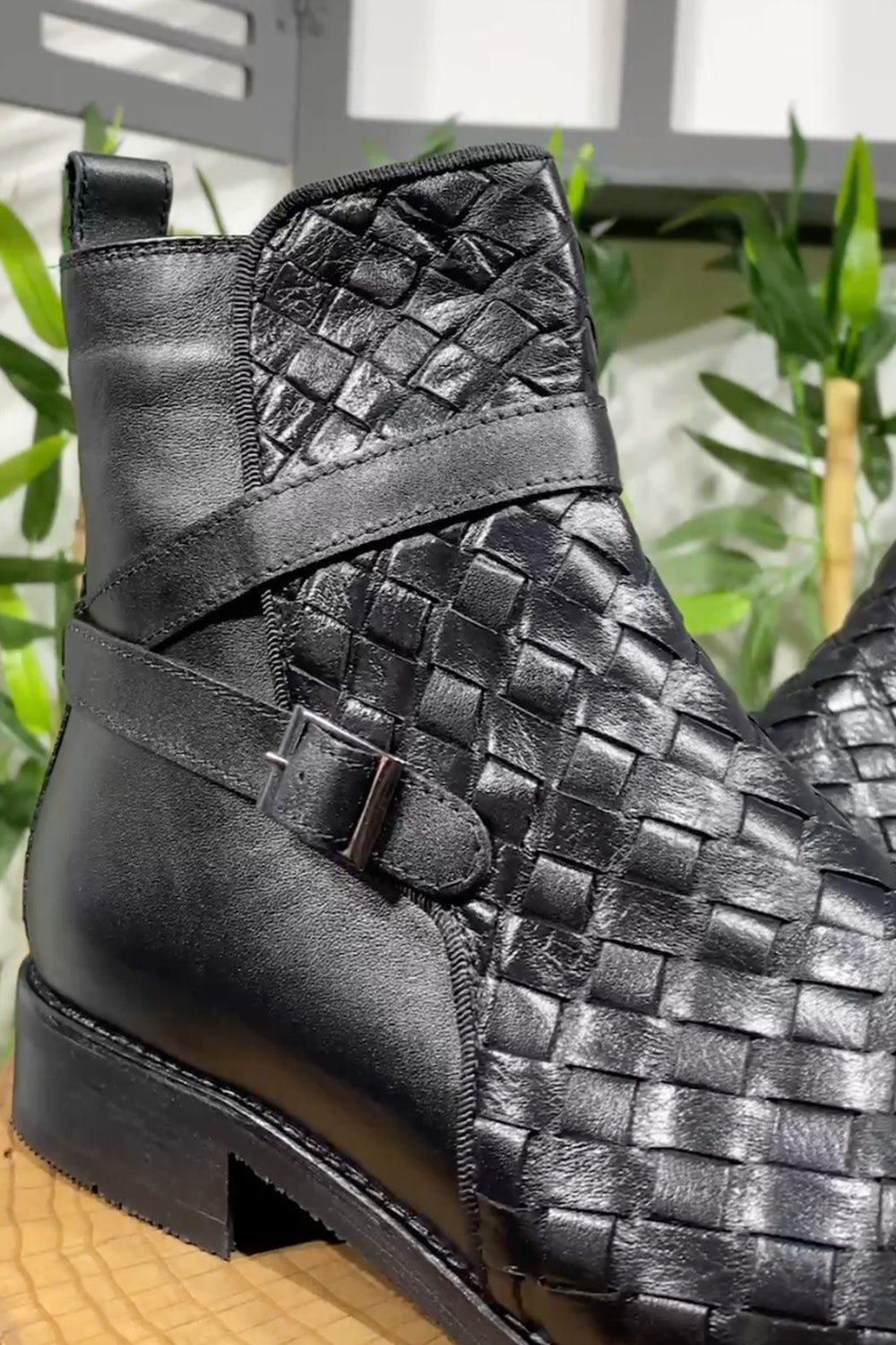Close-up of Mazonni textured sole and woven leather pattern in black high-top boots