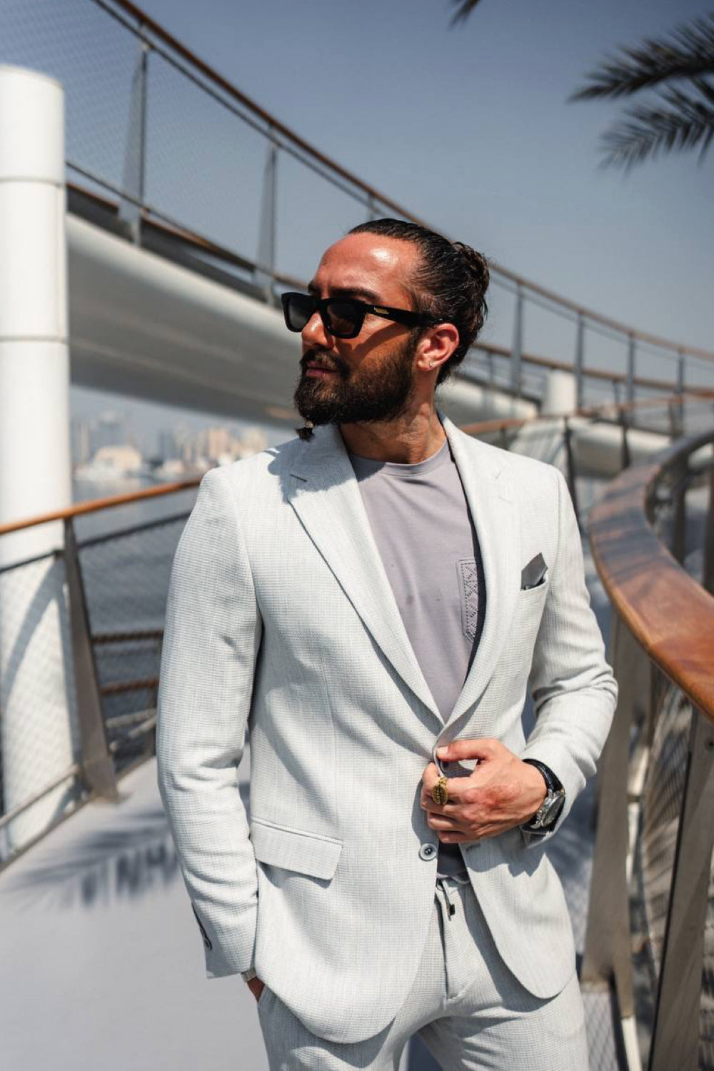 Mazonni pale grey suit for men styled with a crewneck tee and pocket square, ideal for daytime events or rooftop meetings