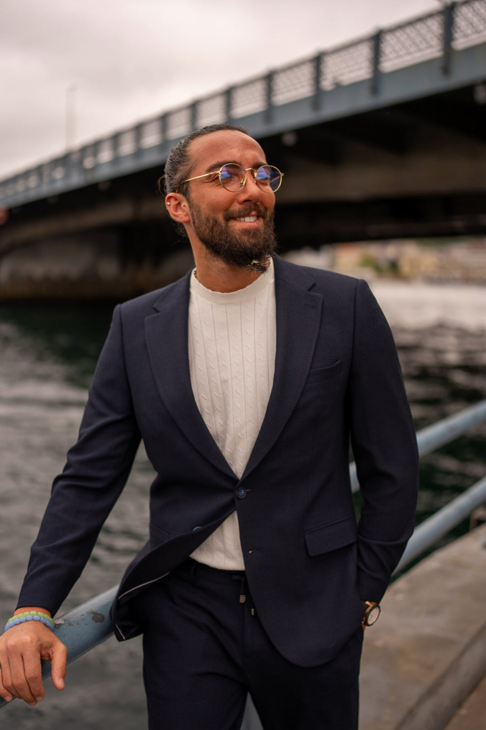 Elegant Mazonni dark blue blazer and trousers set worn casually with a white tee, ideal for contemporary men’s fashion styling by the water