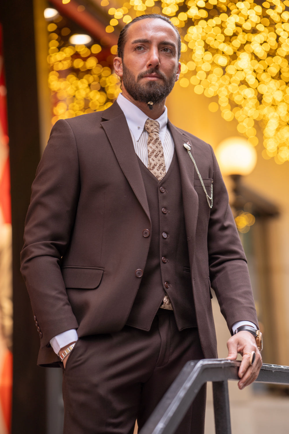 Mazonni men's brown tailored suit for special occasions, styled with a crisp shirt and patterned tie