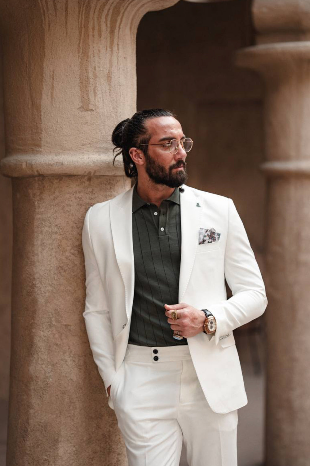 Classic men's white suit by Mazonni styled with a dark green shirt and pocket square, perfect for formal occasions