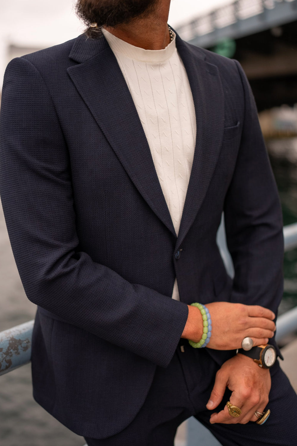 Close-up of a Mazonni navy suit jacket with white t-shirt and accessories, highlighting premium men’s formalwear with a casual twist