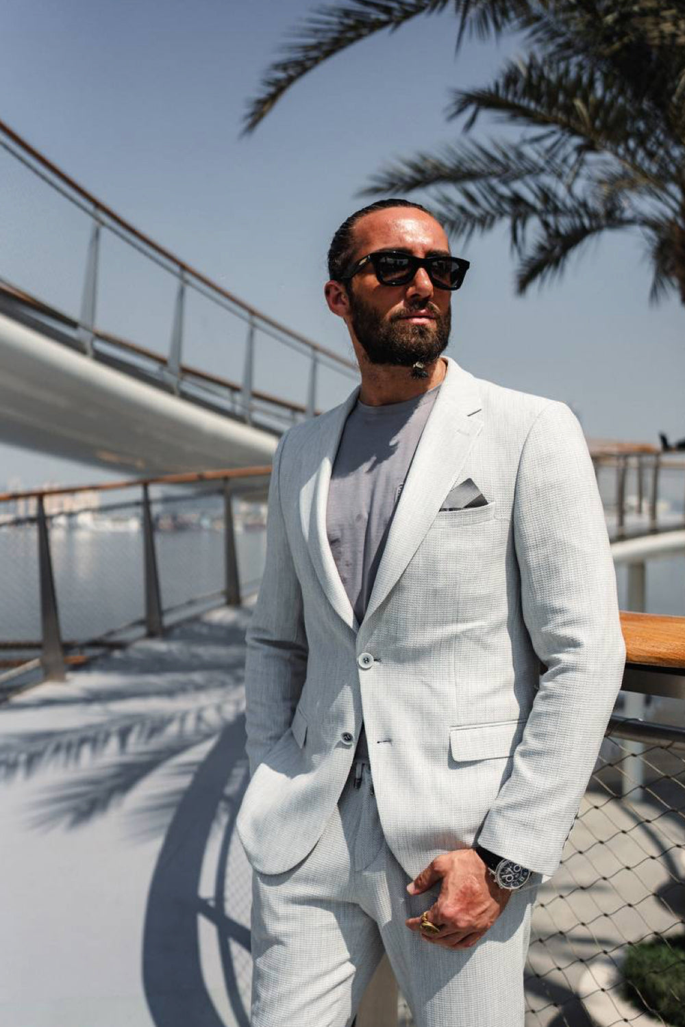 Light grey Mazonni men's suit paired with a casual t-shirt and sunglasses, perfect for smart summer outfits with a relaxed edge
