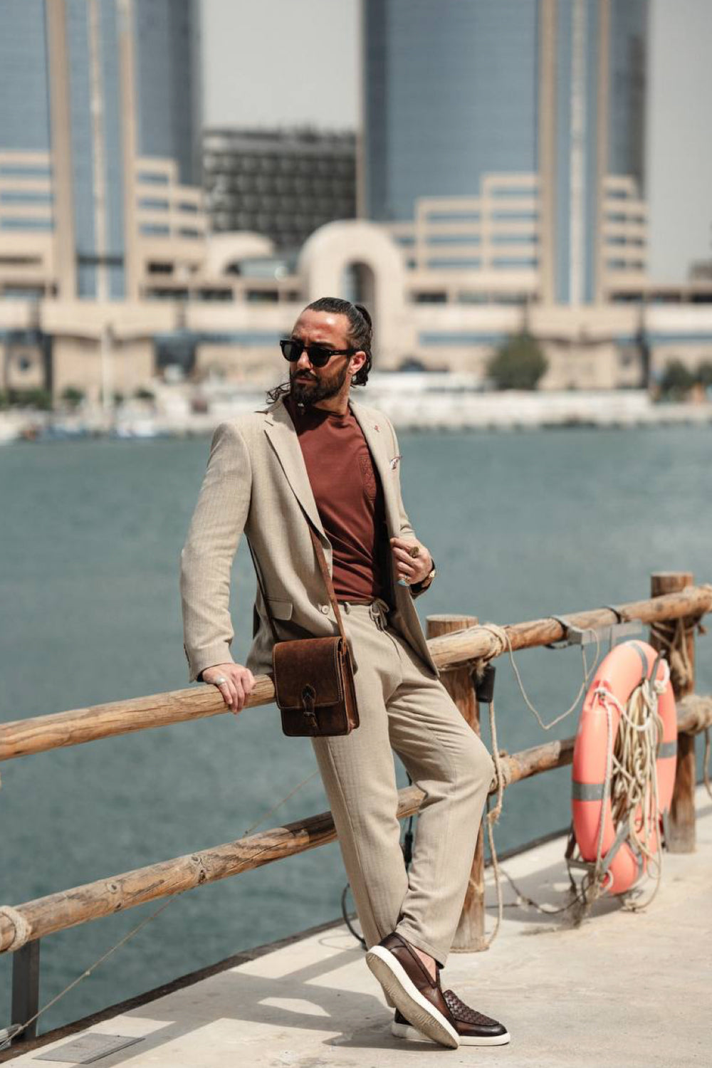 Mazonni beige two-piece suit for men worn with a rust-colored shirt, ideal for stylish warm weather business casual looks by the water