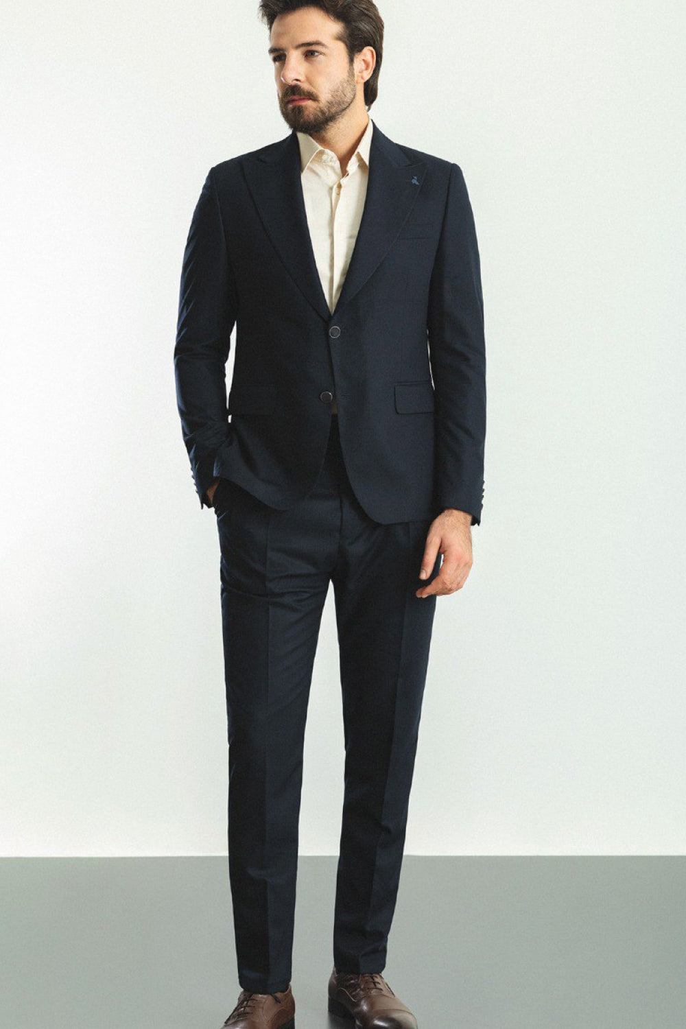 Navy blue formal suit for men by Mazonni, styled with a cream shirt for a classic business look