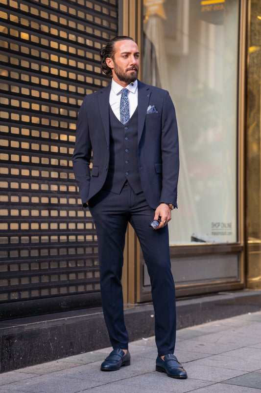 Dark navy men's three-piece suit by Mazonni with vest and tie, ideal for business meetings and formal occasions
