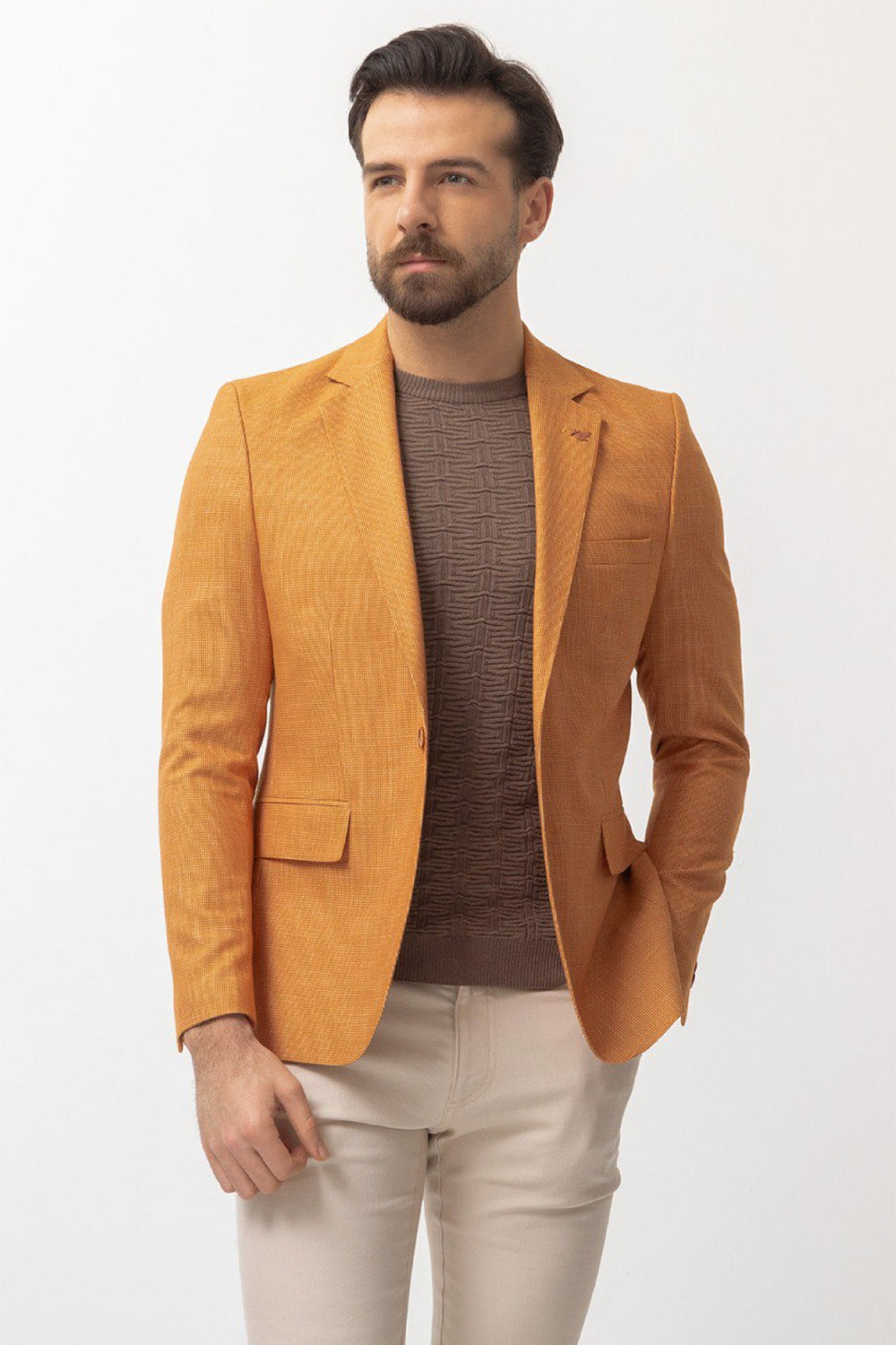 bright orange blazer for men by Mazonni, paired with brown knit top and beige pants for stylish casual look