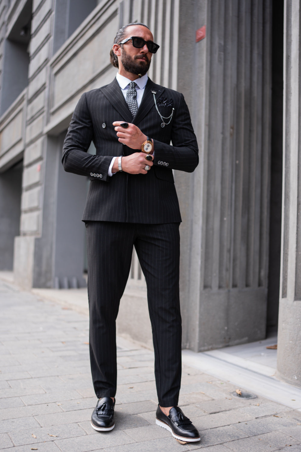 Classic black pinstripe suit by Mazonni for men, styled with a white shirt and tie, formal business look