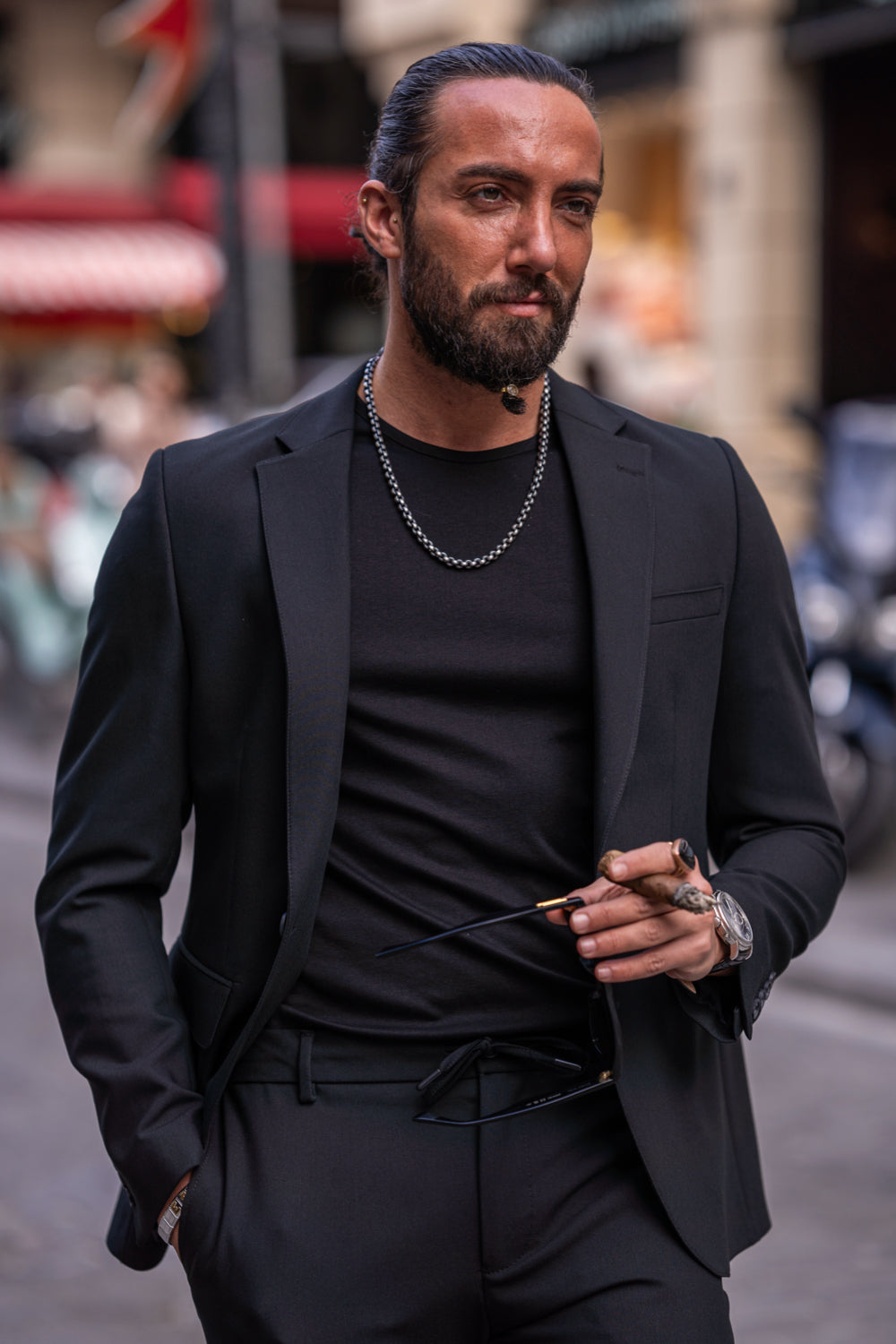 Mazonni black slim fit suit for men paired with a minimalist t-shirt and chain for a modern urban outfit