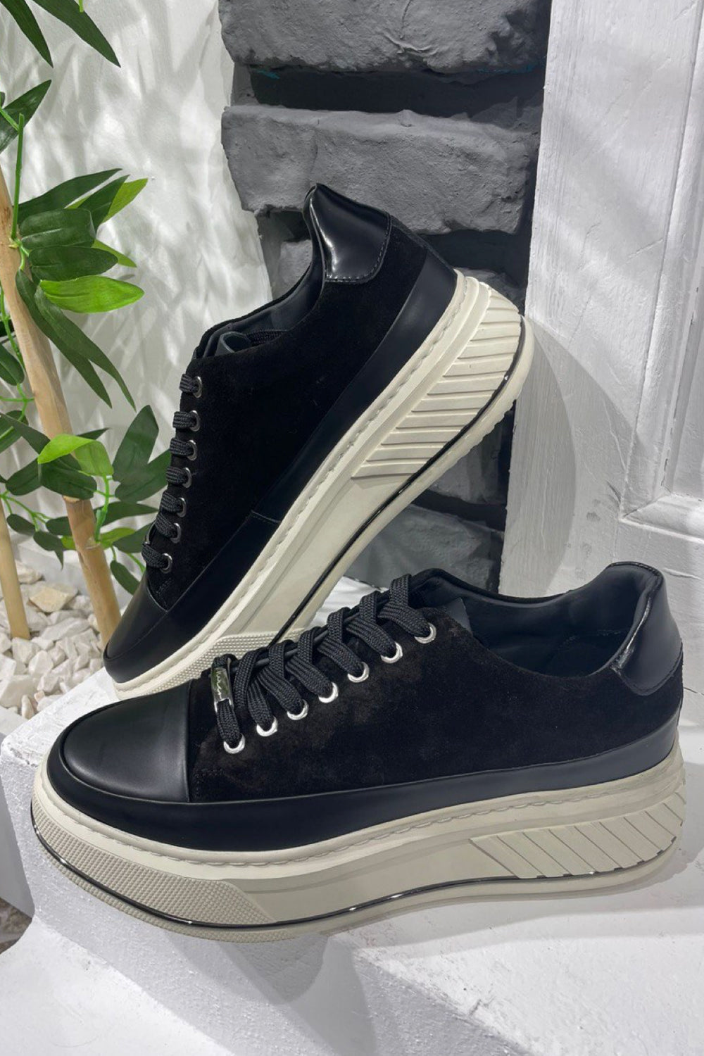 Close-up of black and white Mazonni street style sneakers with bold modern silhouette