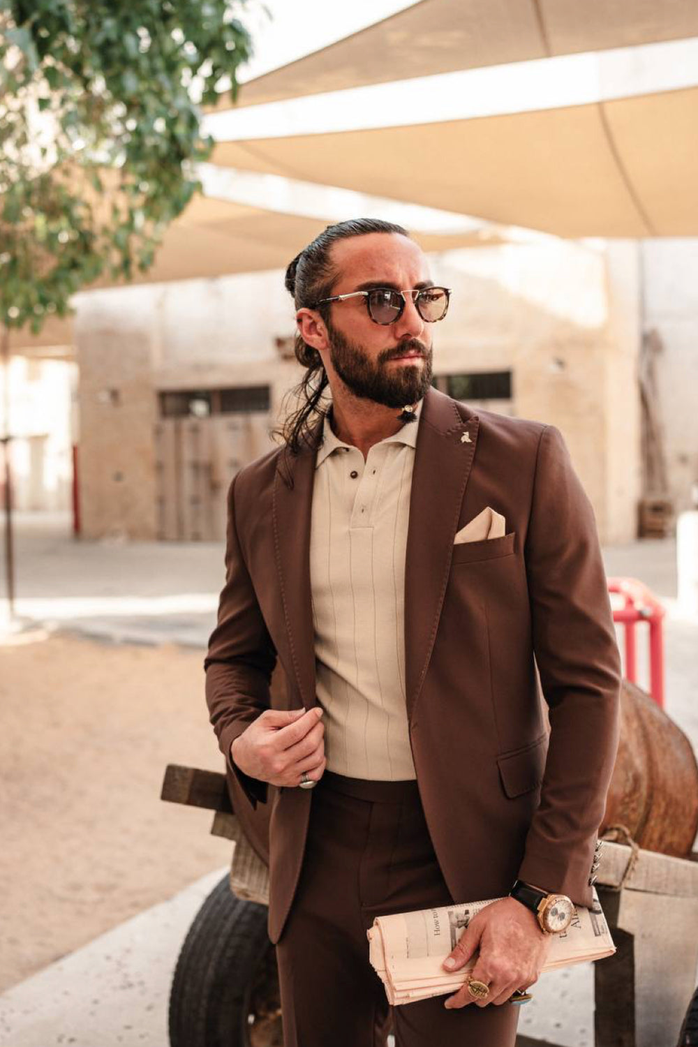Men's brown tailored suit by Mazonni combined with beige tones and accessories, giving a refined yet relaxed look