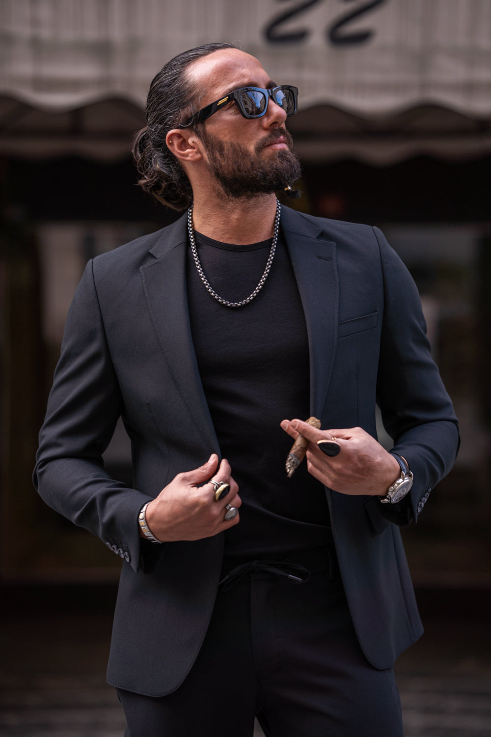Full-body shot of man in Mazonni black suit and casual styling, ideal for fashion-forward city wear