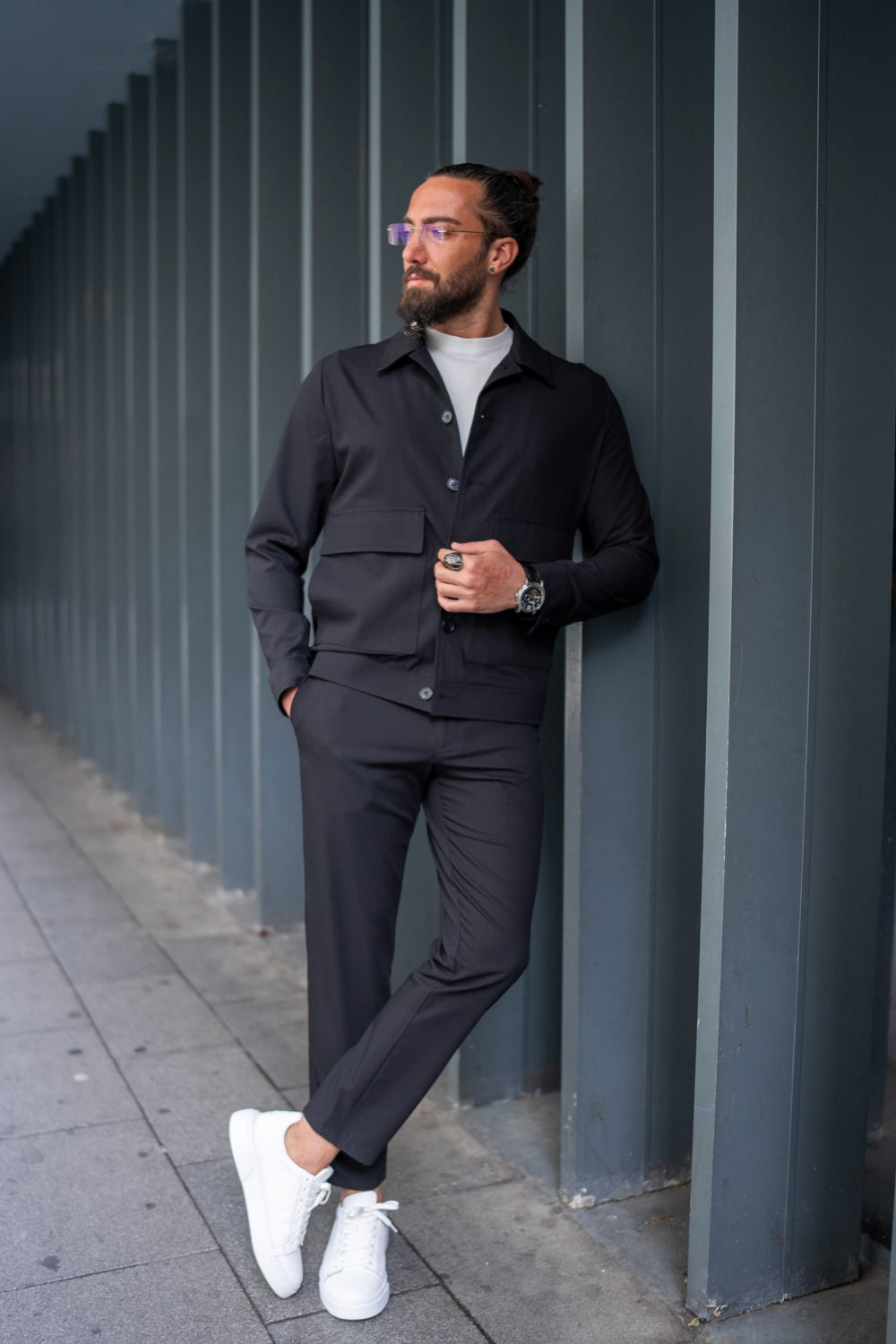 Dark navy men's suit by Mazonni paired with white sneakers and a light turtleneck, stylish casual look for autumn