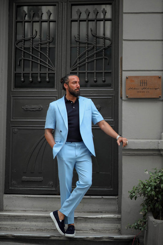 Man wearing light blue short sleeve summer suit with loafers standing confidently