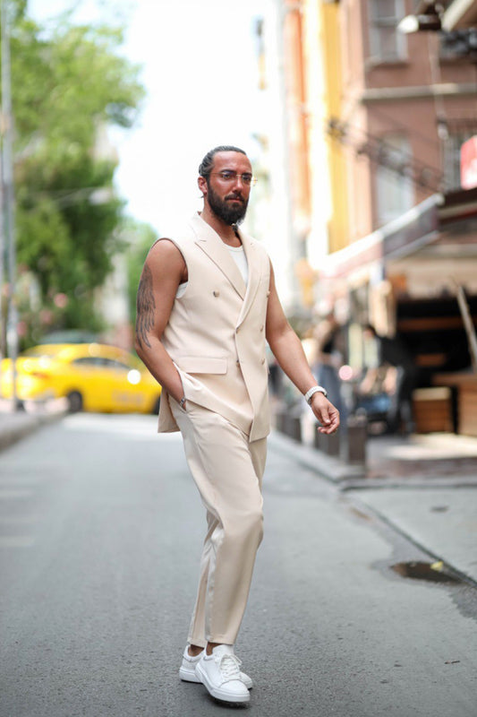 Man wearing sleeveless beige suit set with white sneakers walking confidently