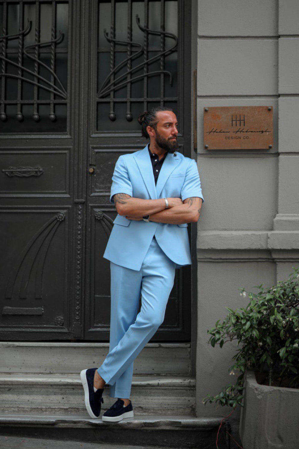 Fashionable summer men’s suit in light blue styled with navy loafers and black shirt